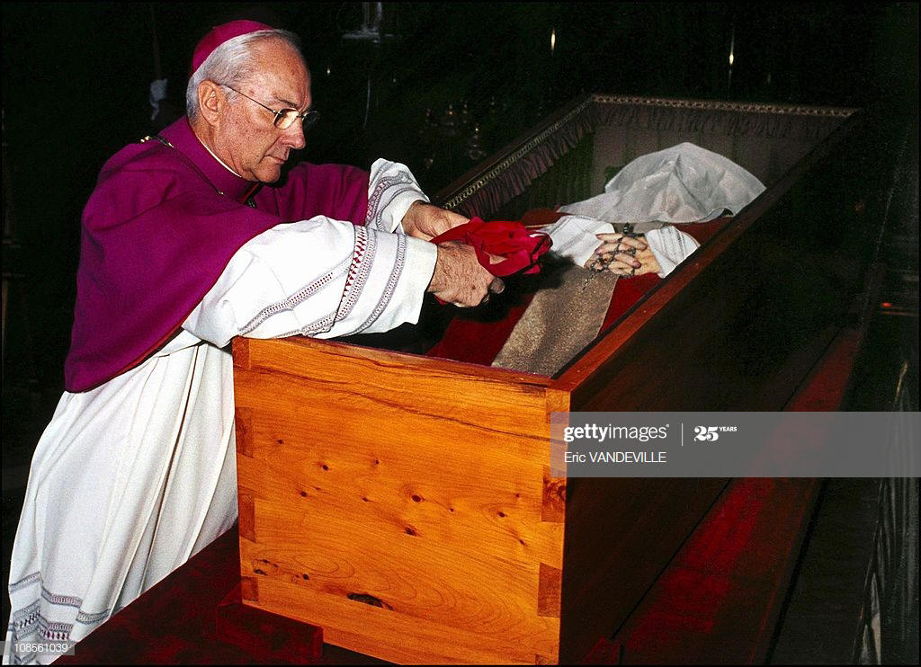 Archbishop Piero Marini puts in Pope John Paul II's coffin a small ...