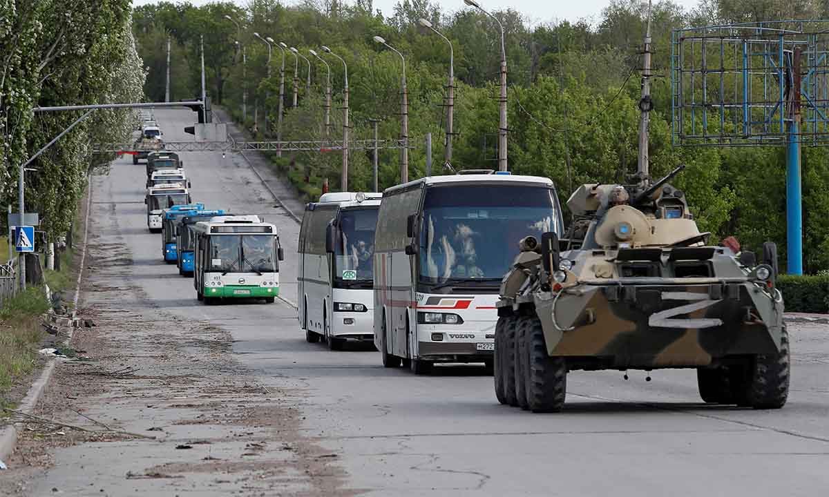 Thiết giáp thuộc đơn vị vũ trang của phe ly khai thân Nga hộ tống đoàn xe buýt chở binh sĩ Ukraine đẫ đầu hàng rời nhà máy Azovstal ngày 17/5. Ảnh: Reuters.