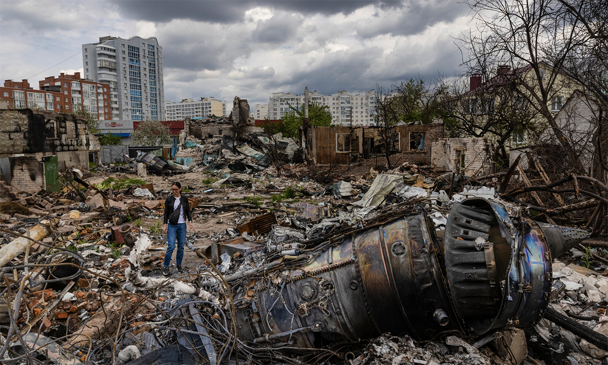 Yulia Hrebnyeva đứng cạnh mảng vỡ tiêm kích Su-34 Nga và đống đổ nát từng là nhà cô ở Chernihiv, Ukraine trong ảnh công bố ngyaf 30/5. Ảnh: NY Times.
