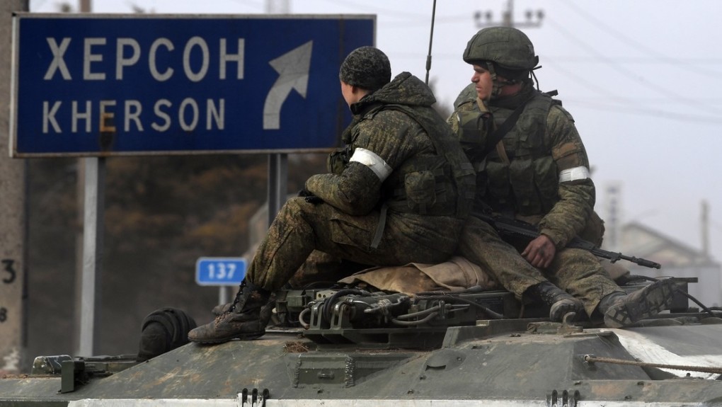 Binh sĩ Nga trên xe thiết giáp cạnh biển chỉ đường về phía thành phố Kherson hôm 24/2. Ảnh: Reuters.