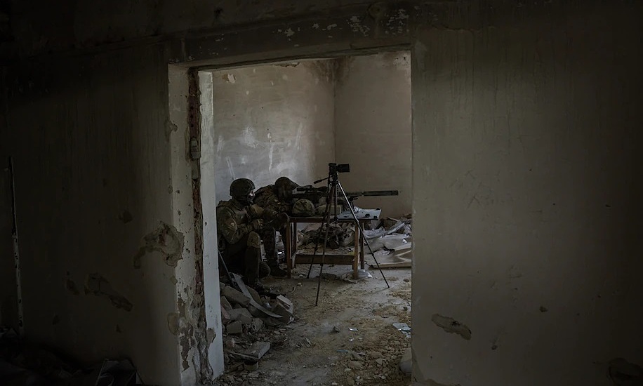 Lính bắn tỉa ngắm bắn tại một căn nhà bỏ hoang ở thị trấn Maryinka, tỉnh Donetsk. Ảnh: Washington Post.