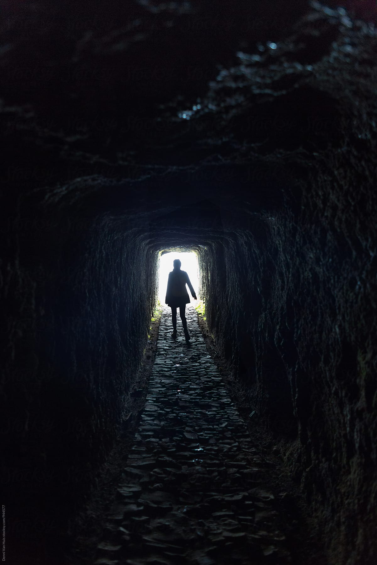 Brave woman walking through a dark tunnel in the mountains. by ...