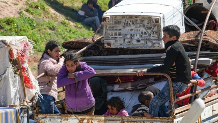 Displaced Syrians join a convoy in Aleppo province